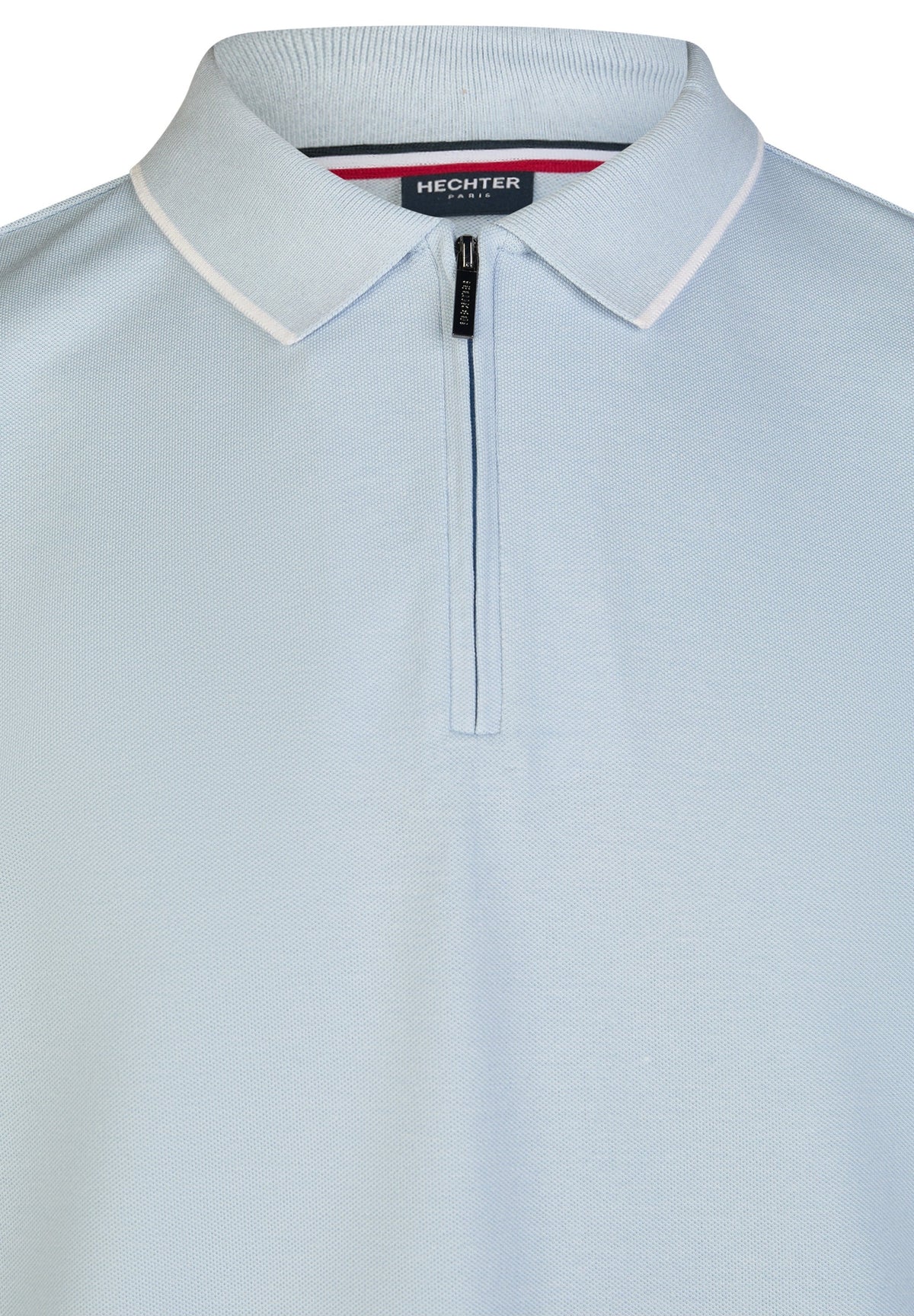 Steel blue piqué knit polo shirt with white-trimmed collar, dark blue quarter-zip placket, black zipper pull, and striped inn