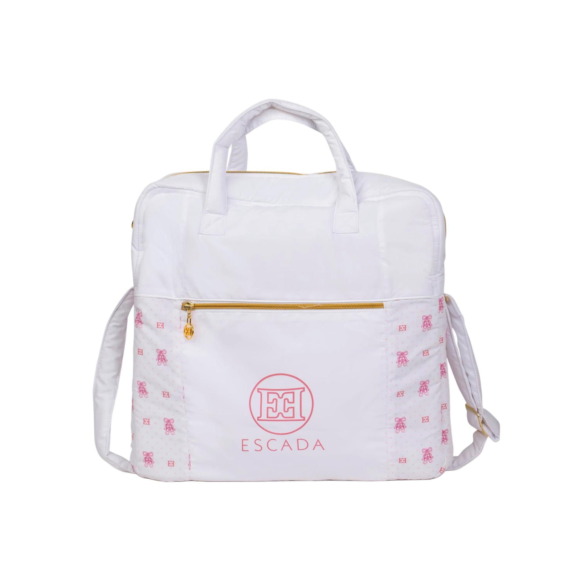 White changing bag with pink ballet shoe and dot pattern, gold-toned zippers, and top handles.