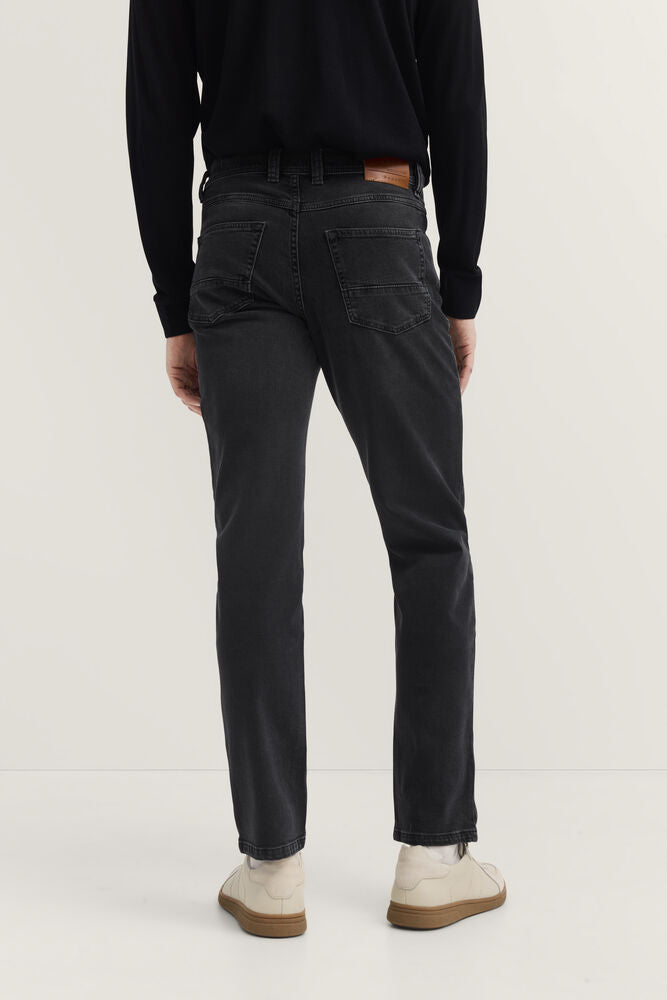 Dark grey faded denim jeans with two back patch pockets and a brown leather-like patch on the back waistband.