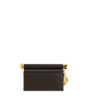 Dark brown clutch with a gold-toned metal bar across the top. It has a spherical embellishment on the left and a leaf-like pe
