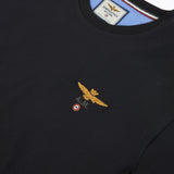 Black crew neck t-shirt with a gold-toned embroidered eagle emblem, "A.M." text, and a red, white, green roundel.