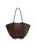 Deep brown wide tote bag with a soft, unstructured shape, smooth faux leather, and thin shoulder straps integrated into pleat