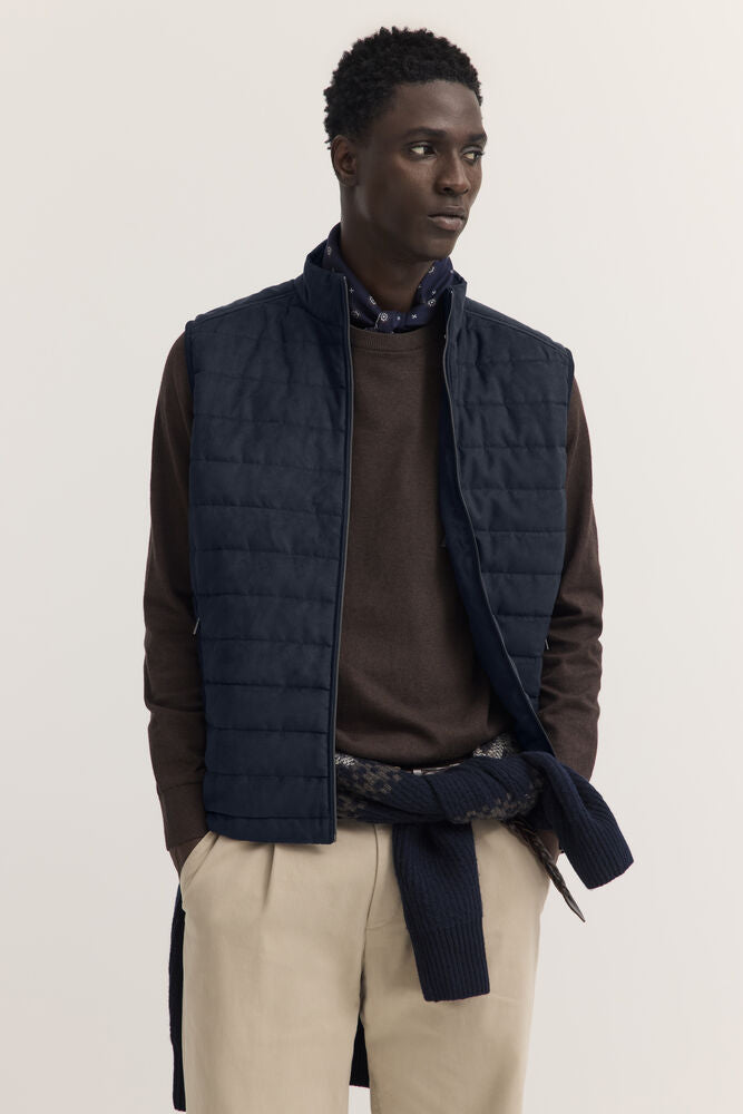 Navy blue quilted vest with horizontal segments, a stand-up collar, and a full-length front zipper.