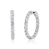 Pair of large round hoop earrings in silver-toned metal, each adorned with clear brilliant-cut stones.