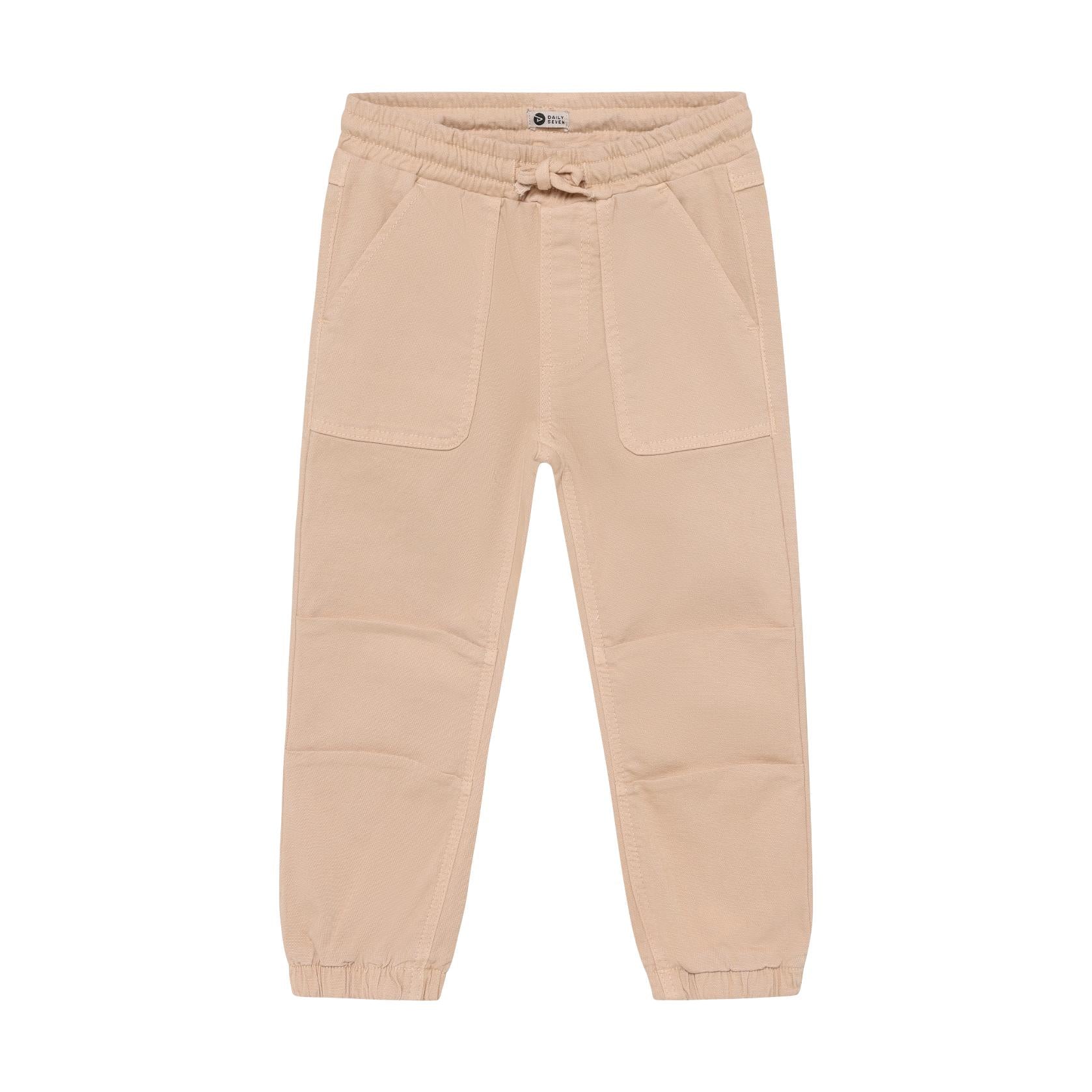 Beige soft twill jogger trousers for kids, featuring an elasticated waistband with a tie, two front patch pockets, and elasti