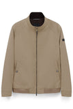 Beige men's blouson jacket with a dark brown stand collar, full-length zip, and two front snap-button pockets.