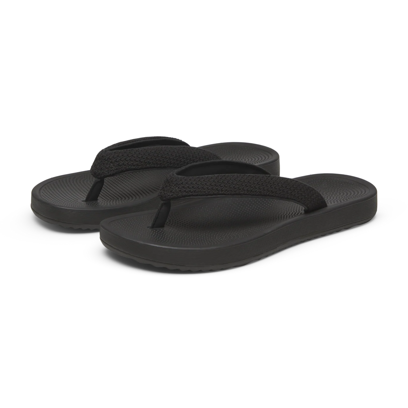 A pair of black flip-flops with wide, textured straps and a textured footbed. The thick sole has horizontal ridges.