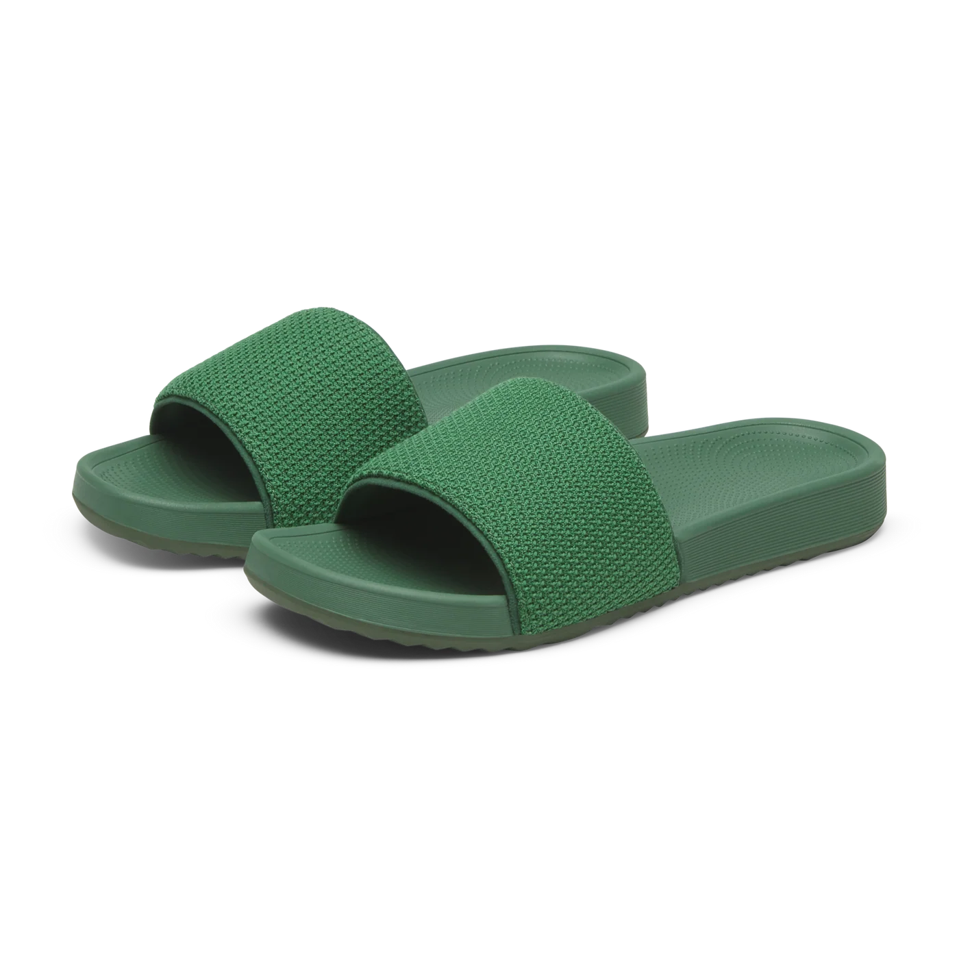 A pair of green slide sandals with textured straps and smooth soles with ridged edges.