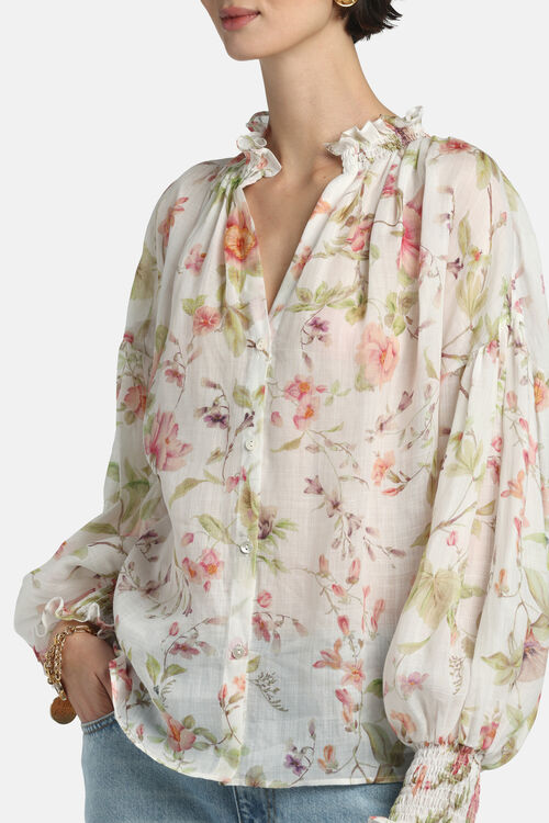 Off-white floral print shirt with ruffled V-neck, button-front, and long voluminous sleeves with smocked cuffs.