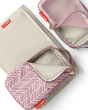 Light beige changing pad, mauve mist chevron-patterned pouch, and mauve mist mesh pouch, all with gold-toned zippers and red