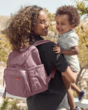Mauve Mist quilted backpack with chevron pattern, gold-toned zippers, a front pocket, and side pockets.