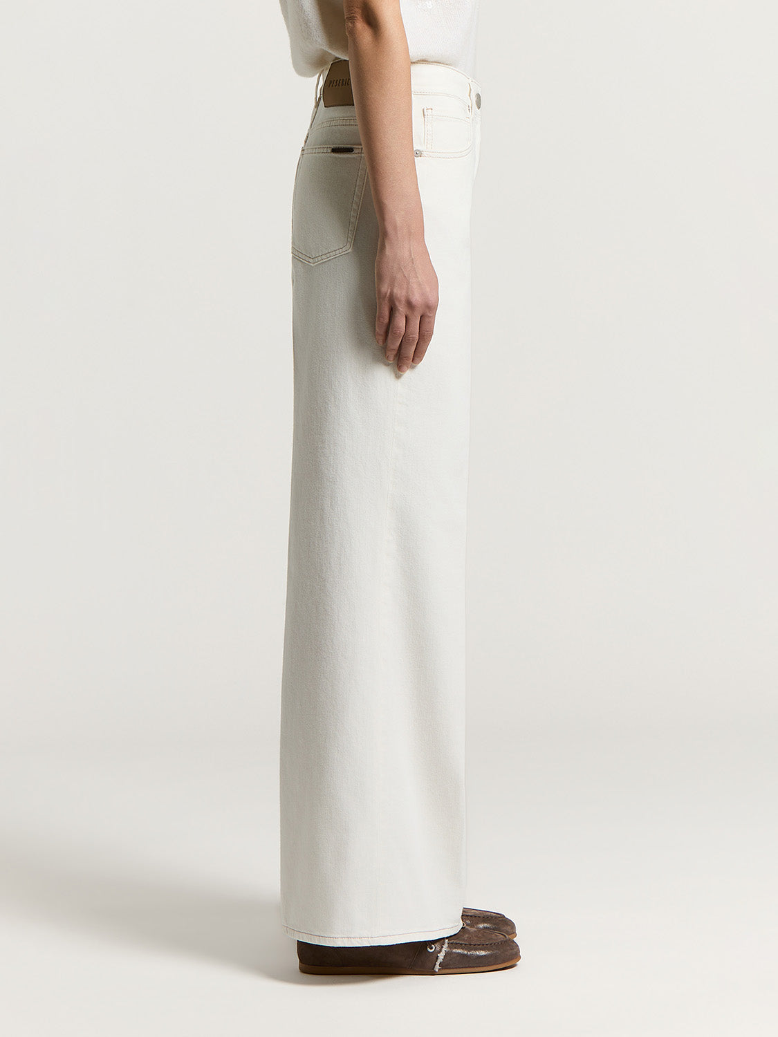 Comet white denim wide-leg trousers with a high waist, visible stitching, and a brown back waistband patch.