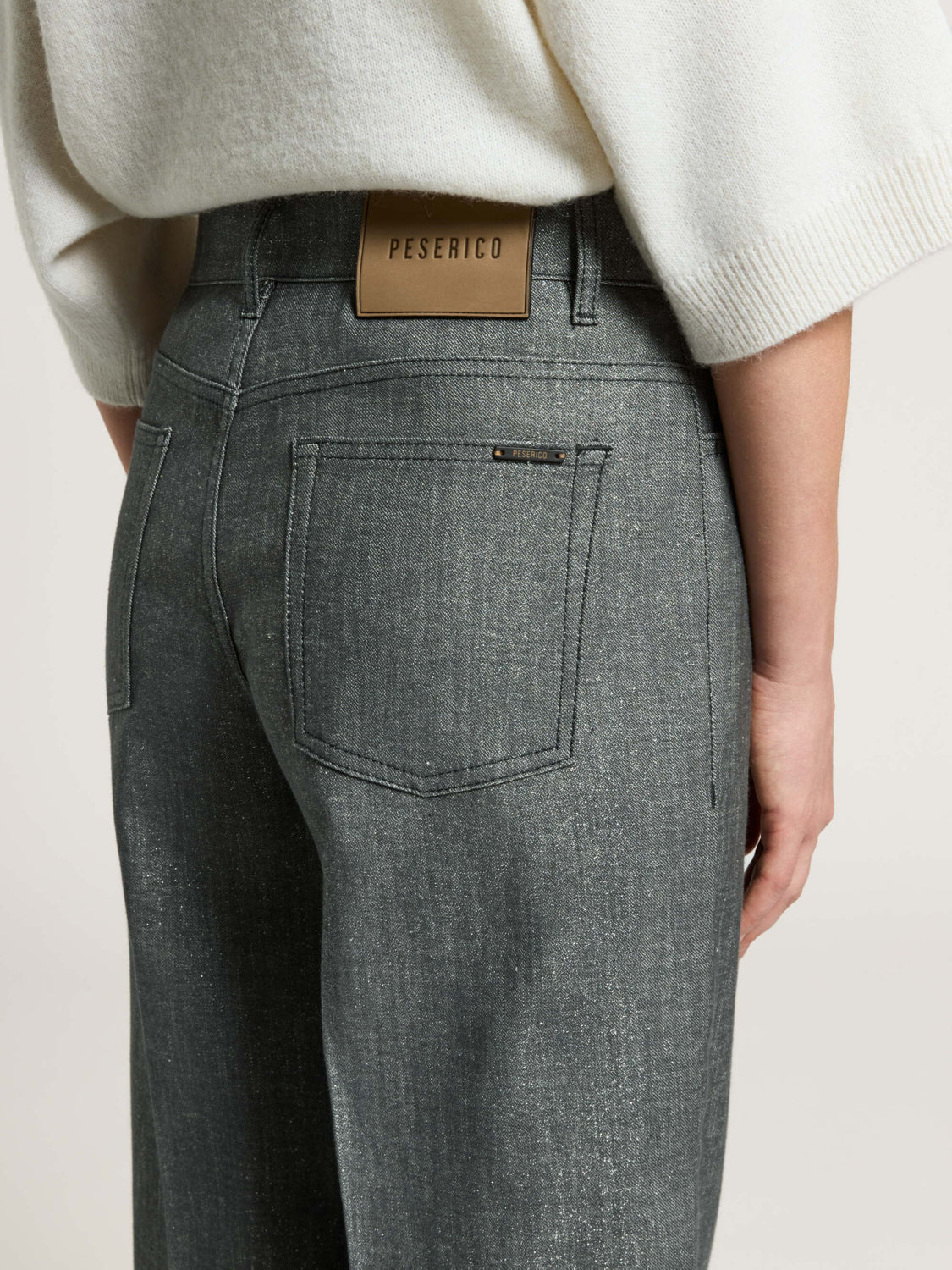 Mercury grey trousers with a subtle shimmer. Features two back patch pockets, a tan branded waist patch, and dark stitching.