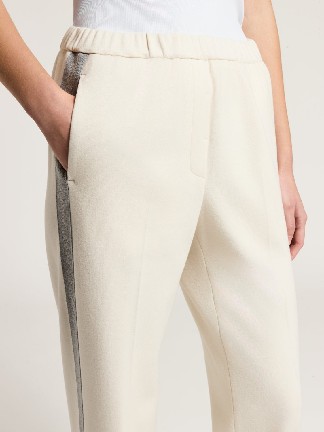 Star dust beige trousers with elasticated waist, side pockets, and a dark grey vertical stripe on the left leg.