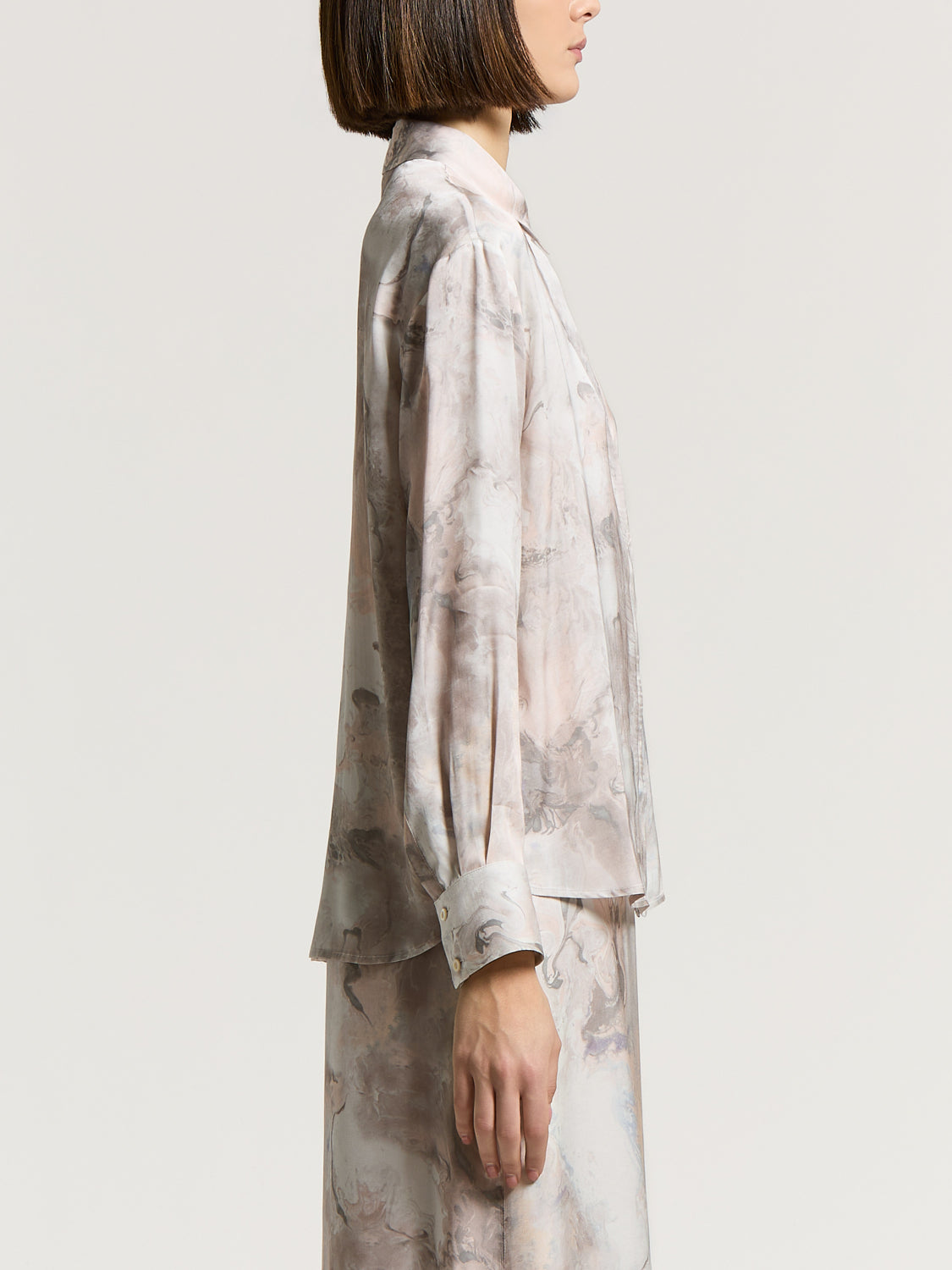 Fluid viscose shirt with a marbled pink, grey, and off-white pattern, featuring a collar and long sleeves with gold-toned but