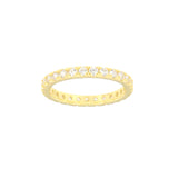 Gold-toned eternity band ring with clear, round zircon stones set continuously around the top half. The underside has small c