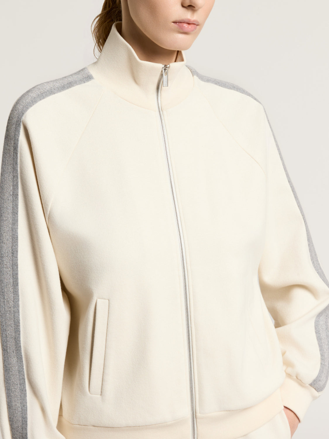 Star dust beige full-zip sweatshirt with a high collar, raglan sleeves, grey ribbed stripes, and front slit pockets.