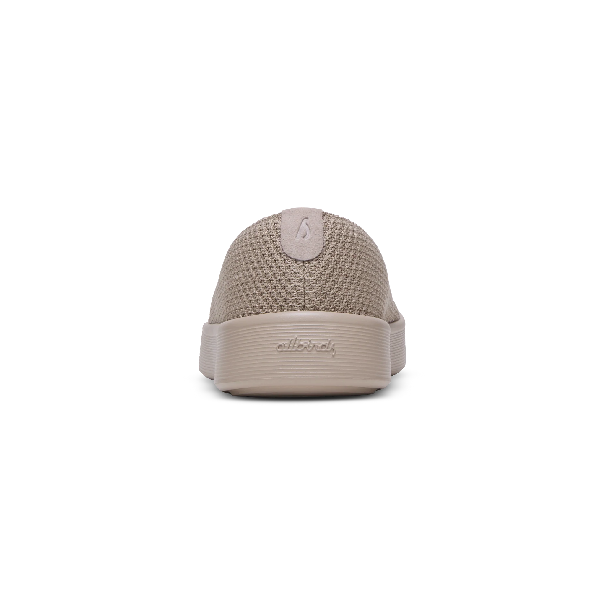 Back view of a tan knitted slip-on shoe with a thick flat sole and a small heel tab. 'allbirds' is embossed on the sole.