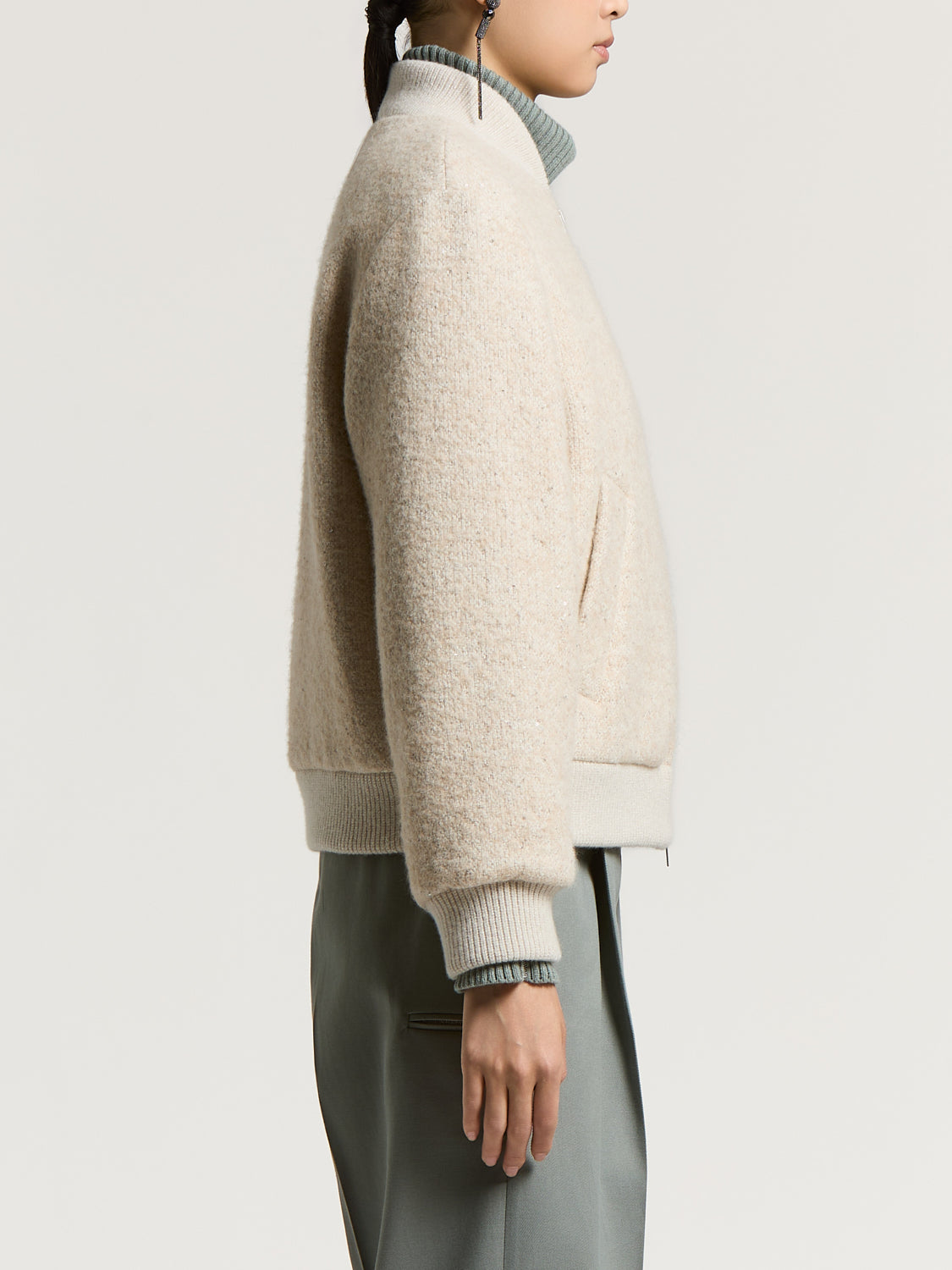 Beige textured bomber jacket with a ribbed stand-up collar, cuffs, and hem. Features a diagonal slit pocket on the right side