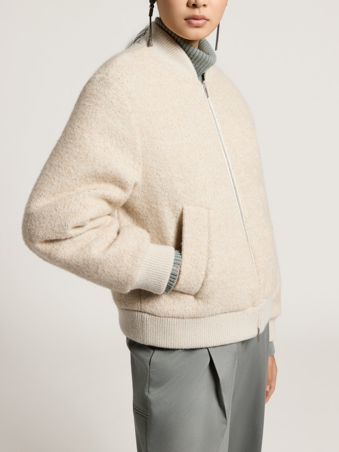 Light beige fuzzy bomber jacket with ribbed collar, cuffs, and hem, and a silver-toned front zipper. Two front patch pockets.