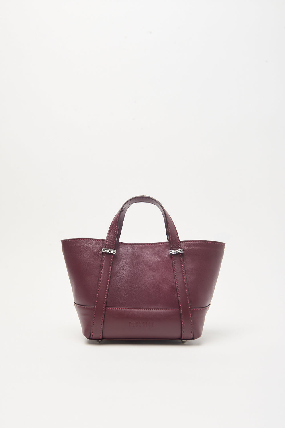 Dark brown leather tote bag with two top handles, silver-toned rectangular hardware, and embossed 'PESERICO' on the front.