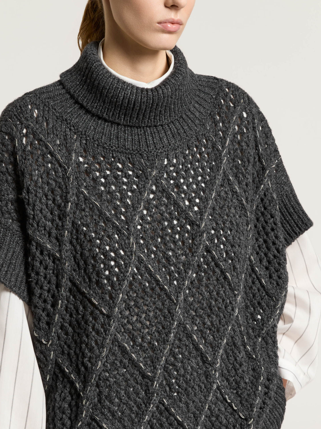 Eclipse gray wool-blend cape with ribbed turtleneck. Open-knit diamond pattern accented with silver-toned threads and short r