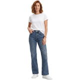Full-length studio shot of a model wearing the Agolde Lana dark wash blue straight-leg jeans styled with a classic white t-shirt and white sneakers.