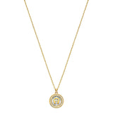 Gold-toned necklace with a circular pendant. The pendant has a gold-toned "A" logo on an iridescent background, framed by cle
