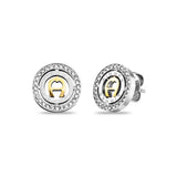 Pair of Aigner silver-toned stainless steel stud earrings with gold-toned central logo and clear crystal halo.
