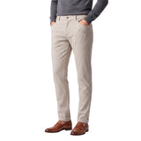 Light beige slim-fit trousers with front slash pockets, rear welt pockets, belt loops, and a cuffed hem.