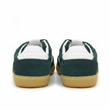 Rear heel view of a pair of ALOHAS sneakers showcasing the textured white leather heel tabs and the gum rubber sole border.