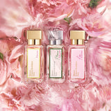 Rectangular clear glass perfume bottle with pink liquid, a light pink label, and a gold-toned rectangular cap.