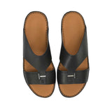 An overhead three-quarter angle view of a pair of Antonio black grained leather Arabic sandals, showcasing their rich texture and structured heritage design against a white background.