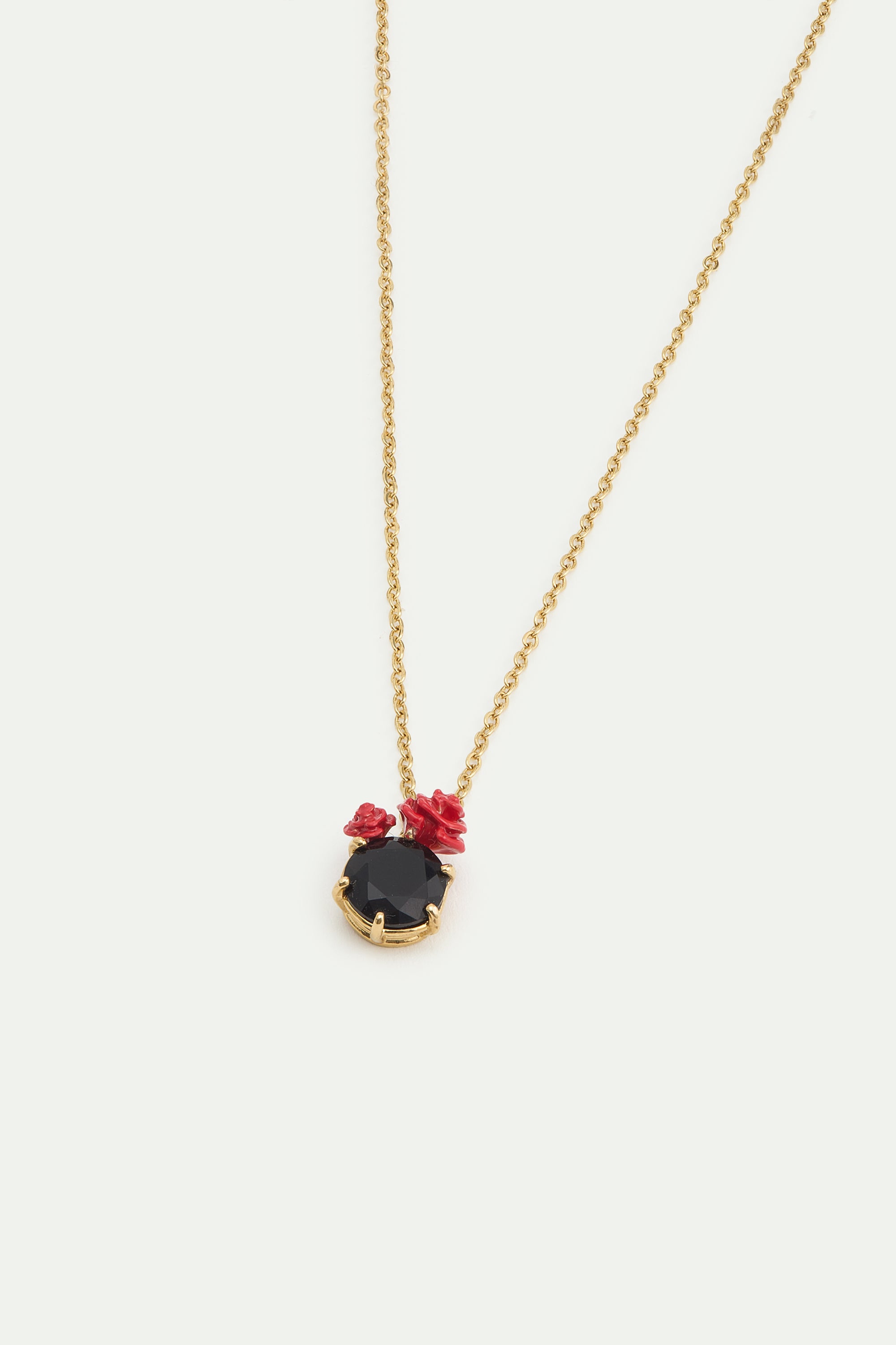 Gold-toned necklace with a faceted black stone pendant, accented by three small red rose details on top.