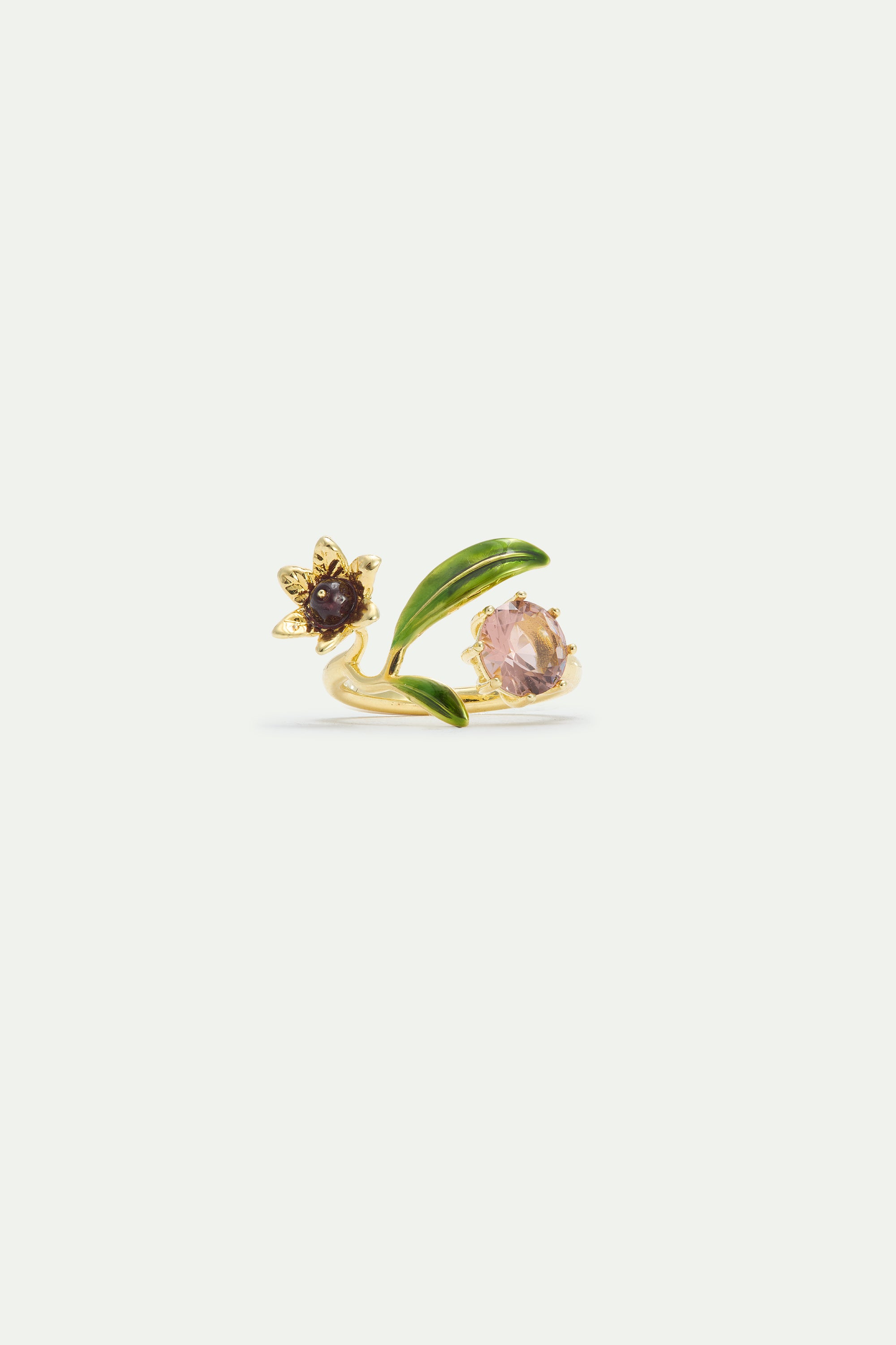 Gold-toned adjustable ring with green enamel leaves, a flower with a dark brown center, and a faceted light pink gem.