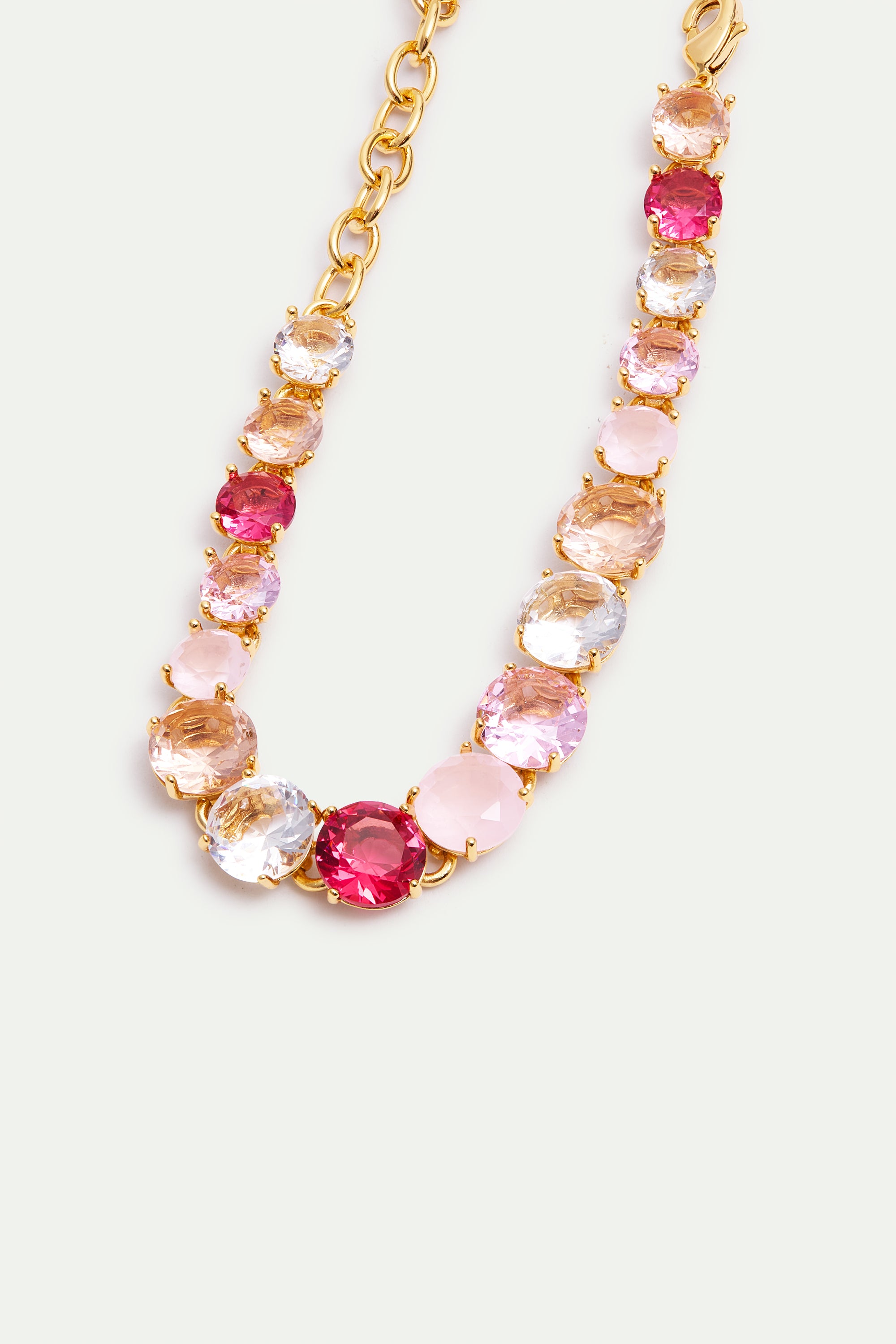 Gold-toned bracelet with round, faceted stones in clear, light pink, fuchsia, and light purple, set in individual bezels, wit