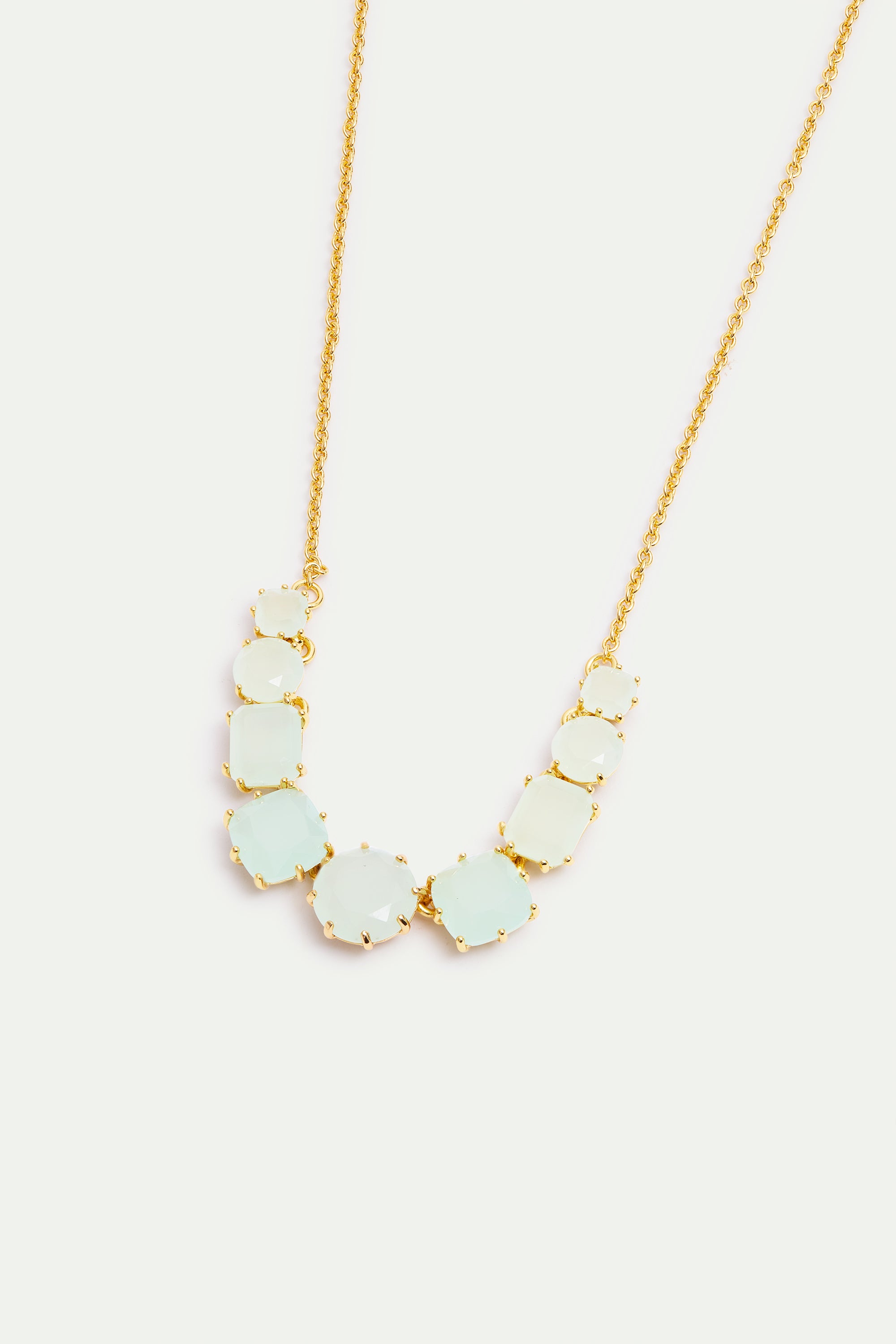 Gold-toned necklace with a curved row of faceted pale aqua and light green stones in varied shapes, each in a gold-toned claw
