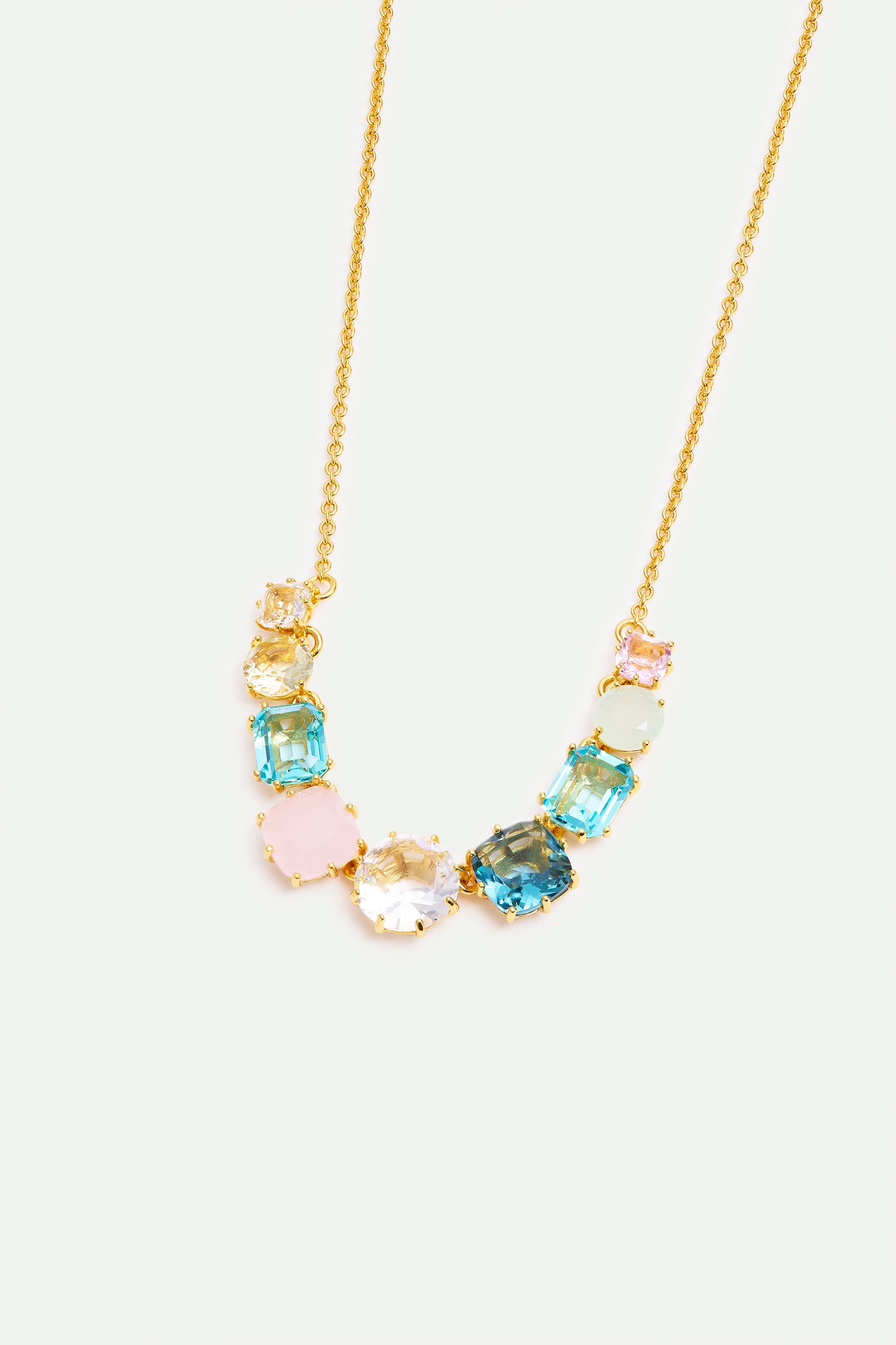 Gold-toned chain necklace with an arc of faceted gemstones in various shapes and pastel colors: blue, pink, clear, yellow, an