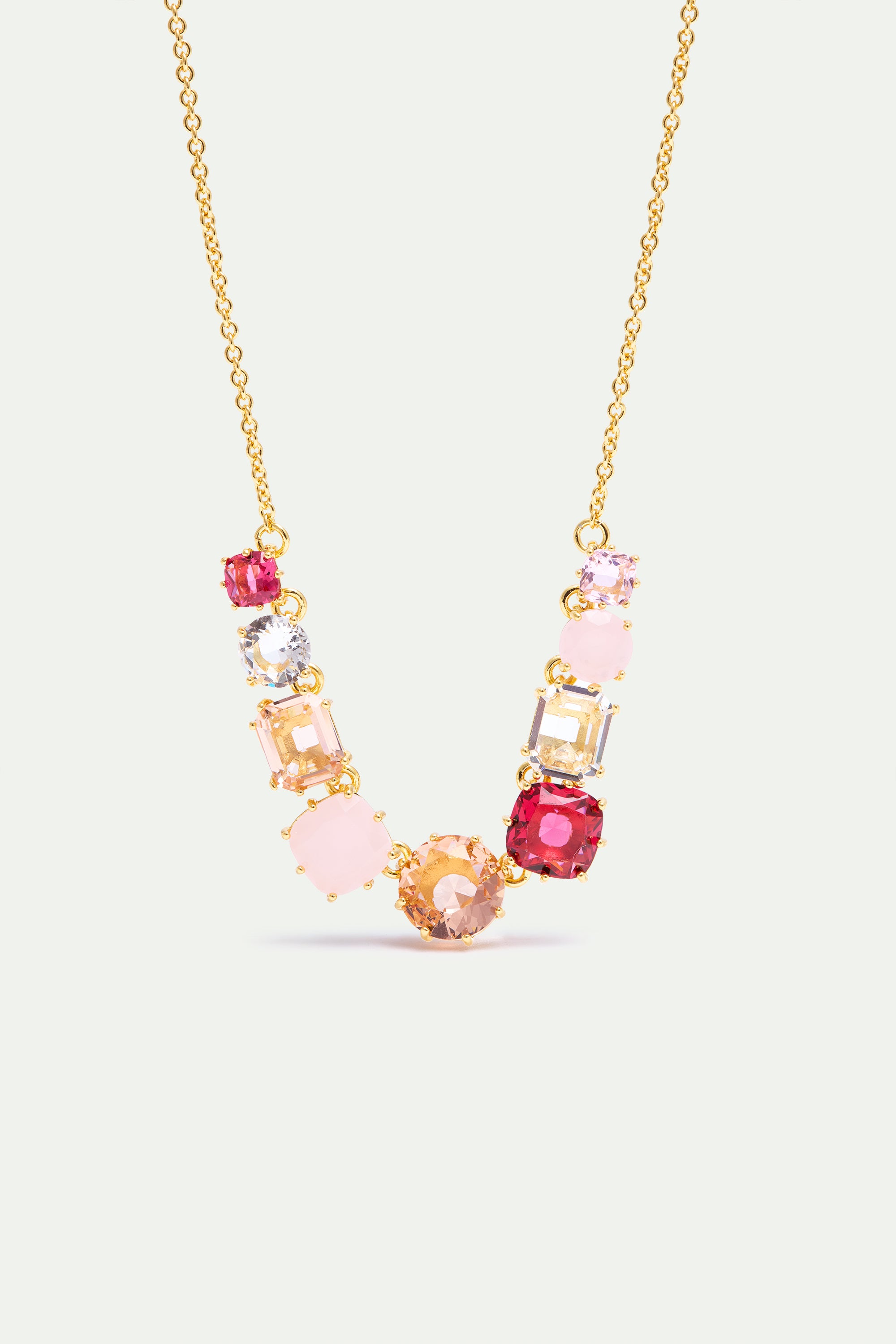 Gold-toned necklace with a central arrangement of pink, red, clear, and amber-toned faceted and cabochon-cut stones.