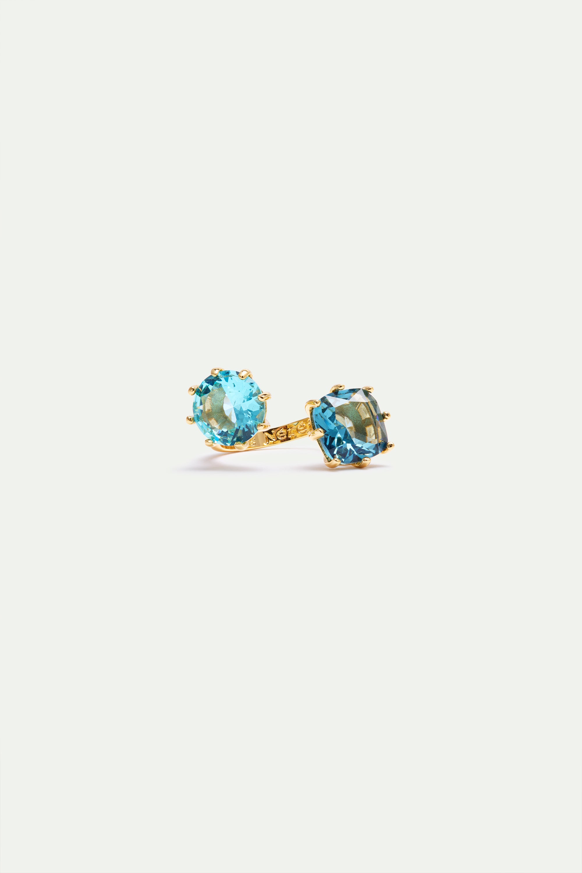 Gold-toned adjustable ring featuring a round light blue gemstone and a square darker blue gemstone, both prong-set.