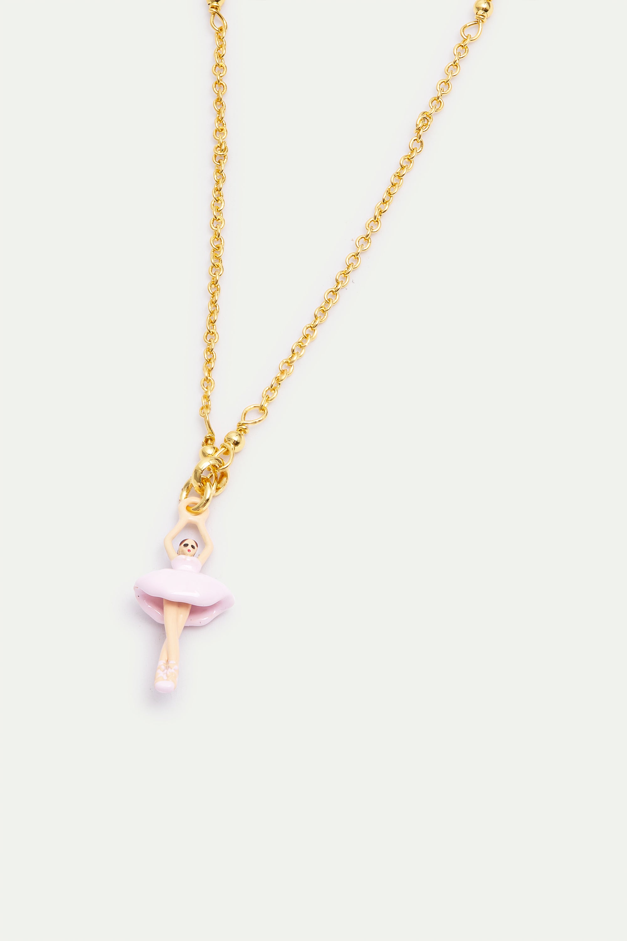 Gold-toned chain bracelet with a light pink and skin-toned ballerina charm, arms raised, on pointe.