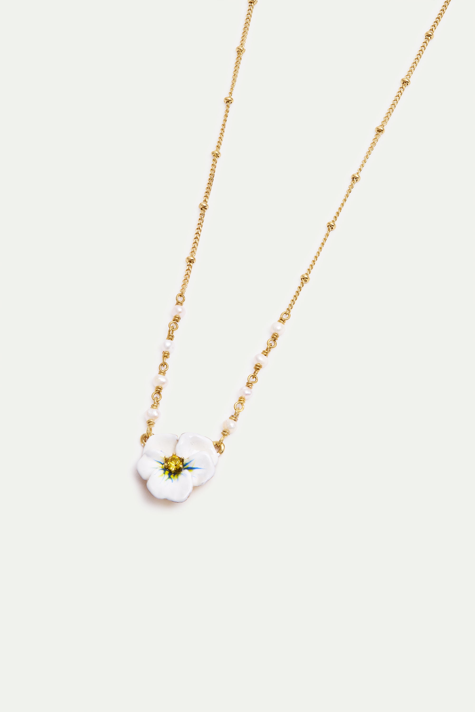 Gold-toned necklace with a white flower pendant featuring a yellow center and blue accents, flanked by sections of small whit