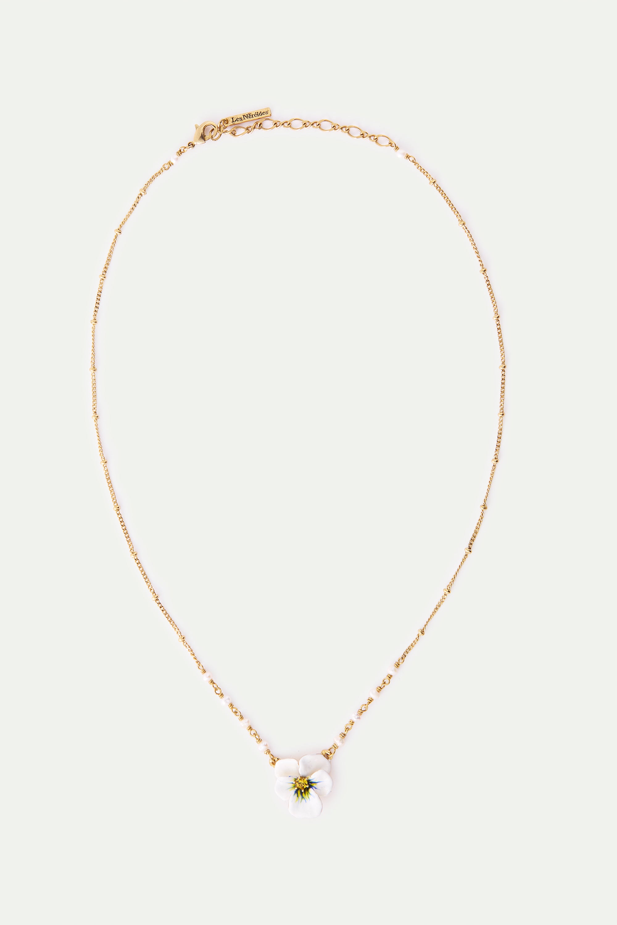 Gold-toned necklace with a white five-petal flower pendant featuring a yellow center. Small white beads accent the chain near