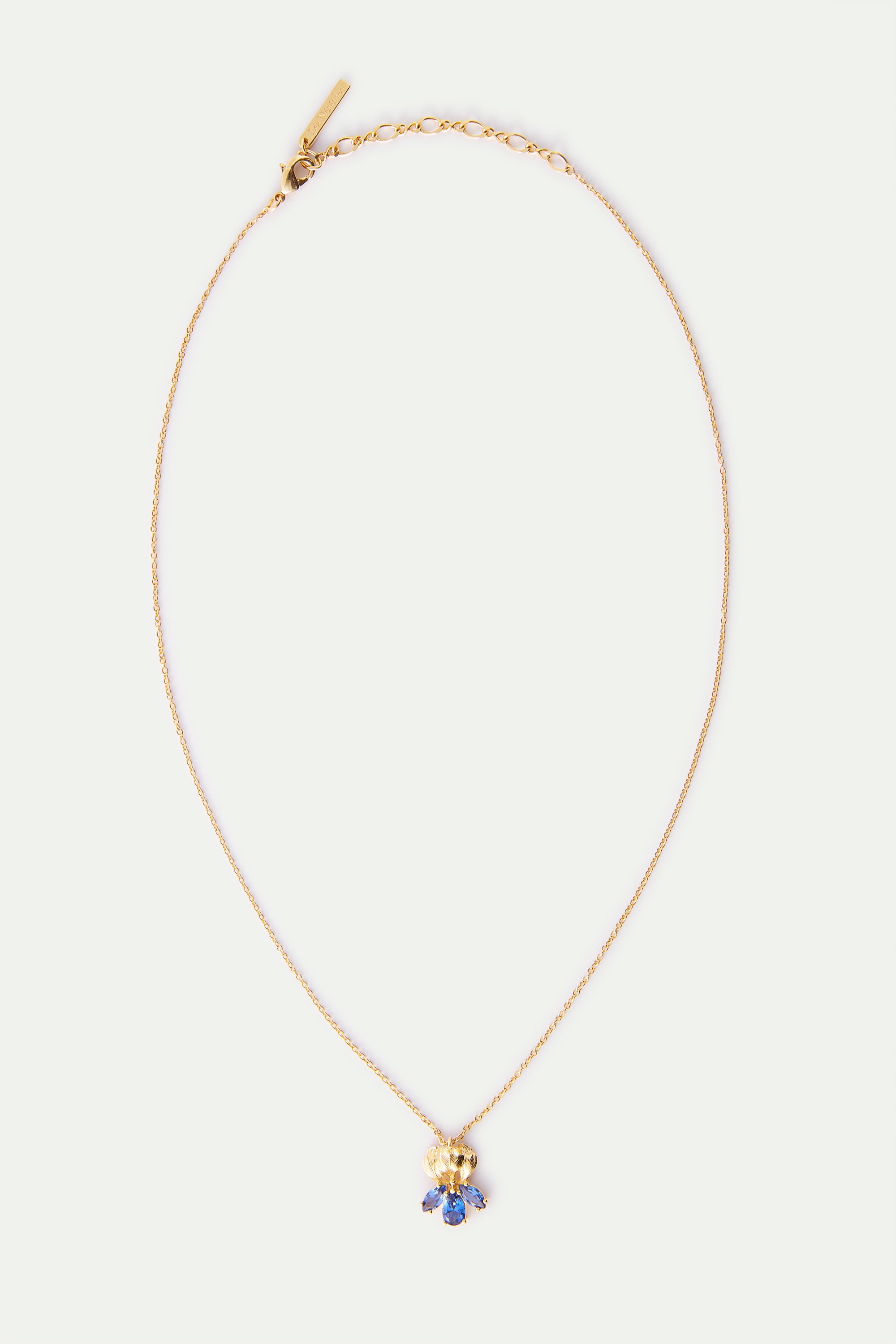 Delicate gold-toned necklace with a textured gold-toned pendant featuring a cluster of blue marquise-shaped stones.
