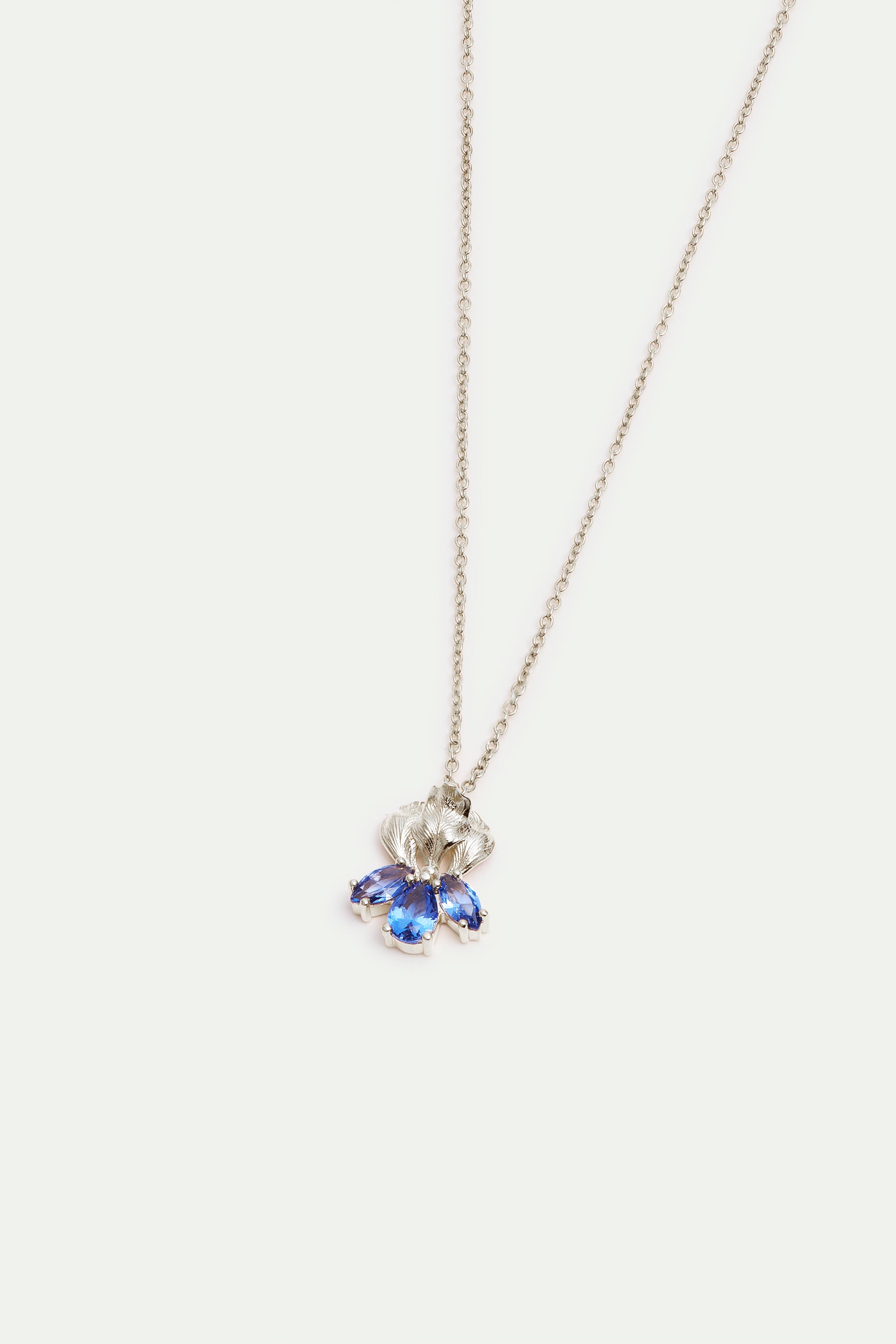 Silver-toned necklace with a textured, fan-like pendant featuring three marquise-cut blue stones.