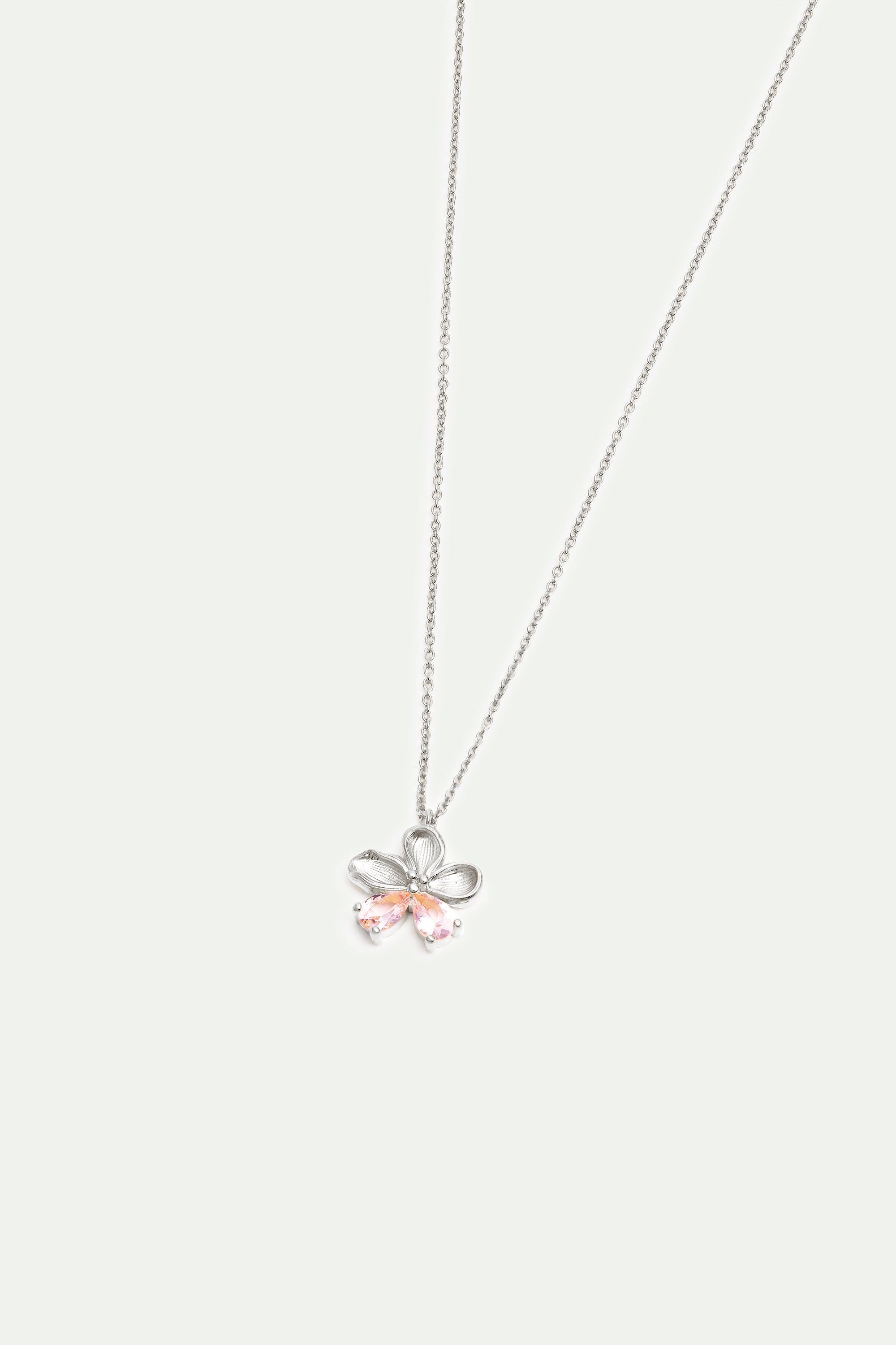Silver-toned necklace with a flower-shaped pendant. The pendant has looped petals and two light pink teardrop-shaped stones.
