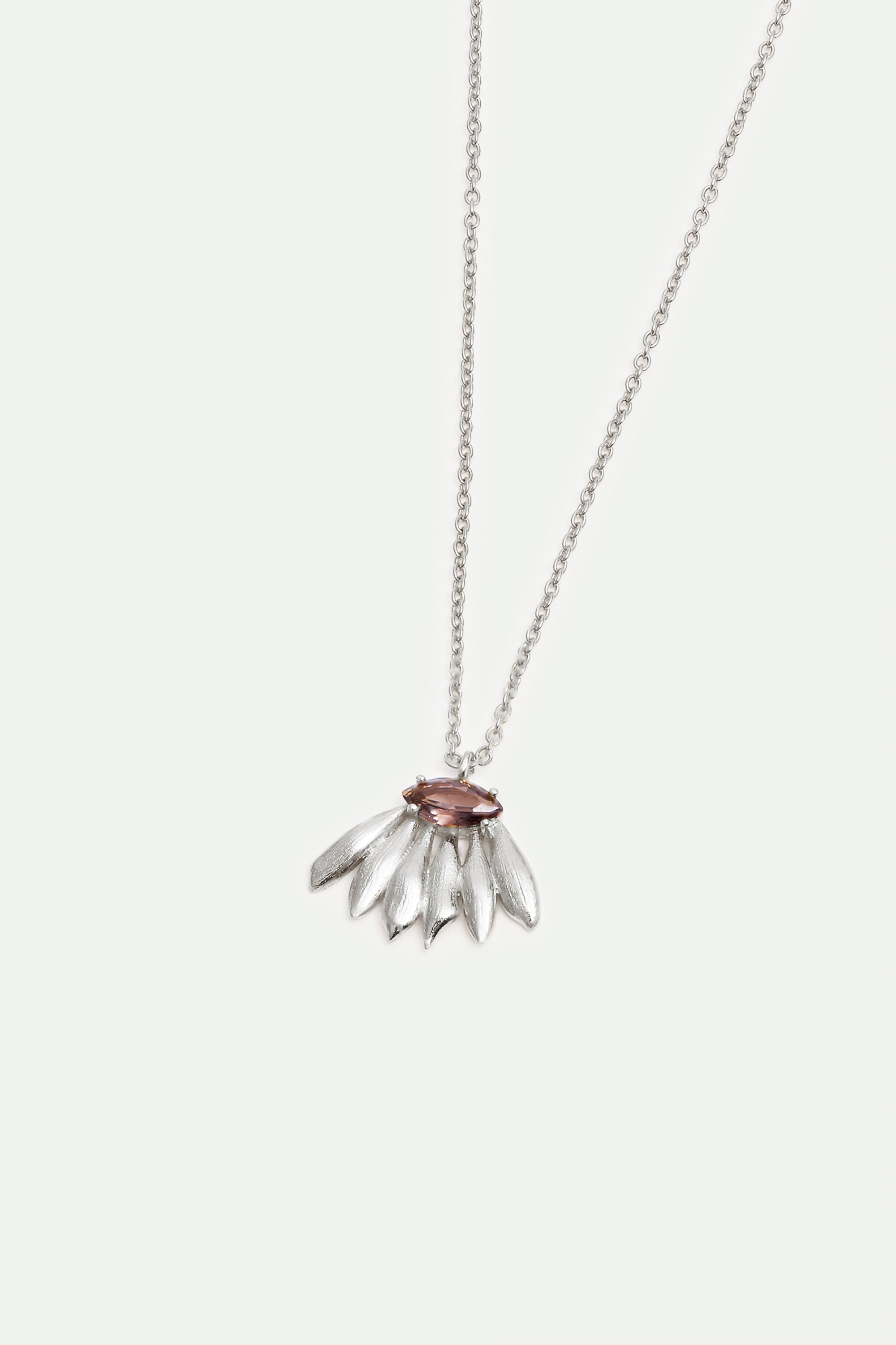 Silver-toned necklace with a mauve marquise-cut stone pendant surrounded by textured, leaf-shaped silver-toned elements.