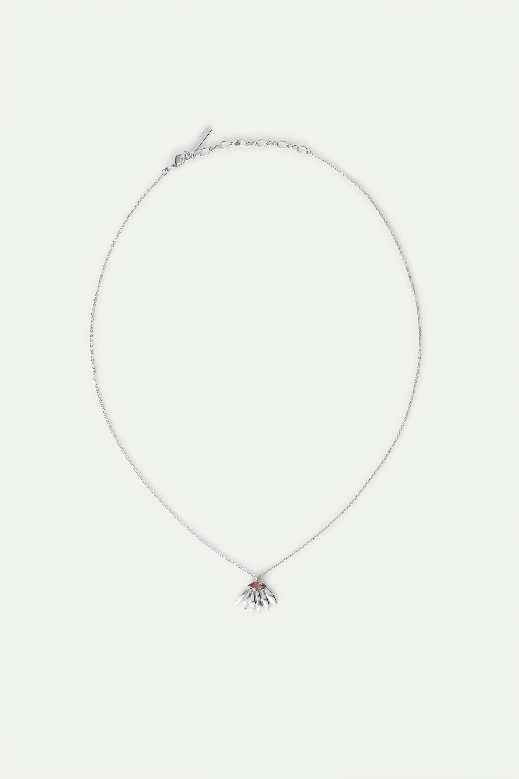 Silver-toned necklace with a delicate chain and a pendant featuring a reddish-brown oval surrounded by silver-toned petal-lik