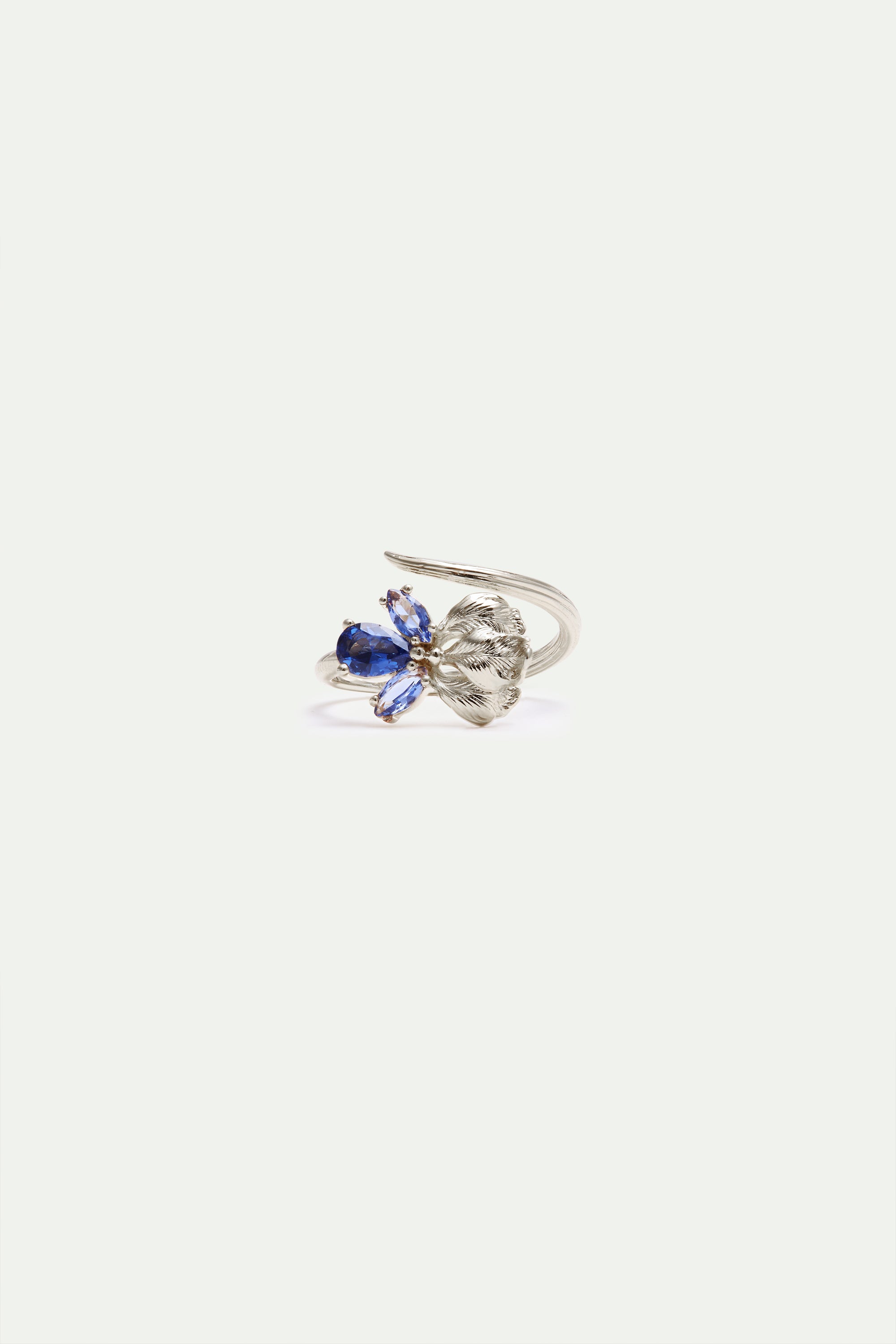 Silver-toned adjustable ring with a sculpted leaf motif and a cluster of blue faceted stones.