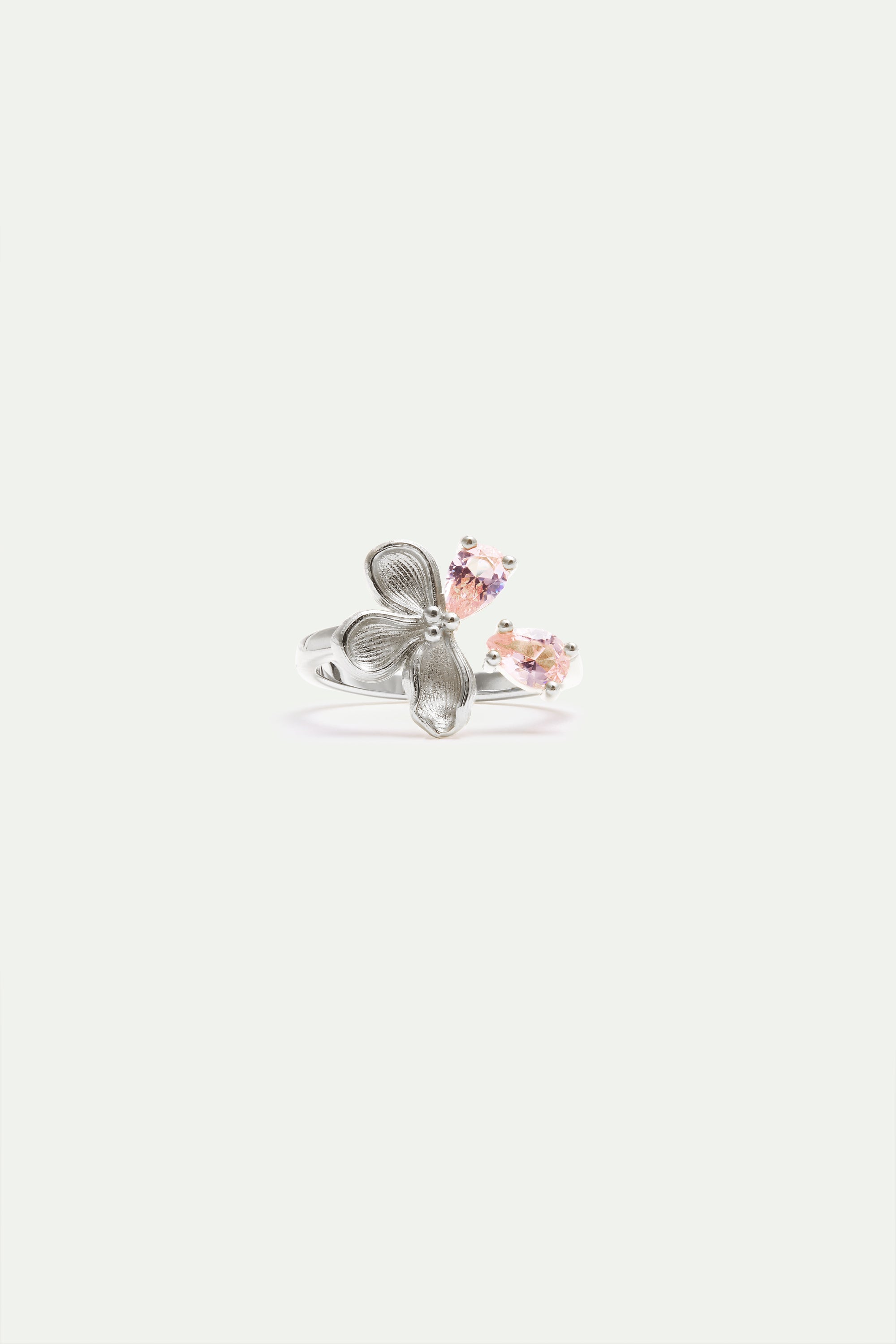 Silver-toned adjustable ring with a three-petal floral design and two pear-shaped faceted stones in light pink and lavender.